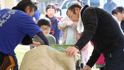 唐箕を使って籾摺り体験をする参加者親子