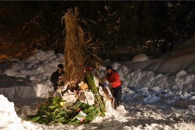 お正月飾りを歳の神へお供えする住民