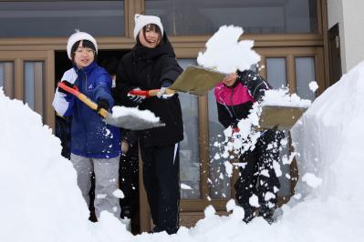 玄関前の雪をよせる様子