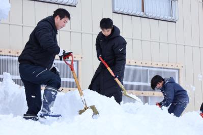 雪を下す2年生とボランティア職員