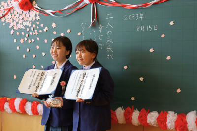 再開の約束をして記念撮影をする卒業生２名