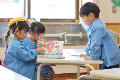 お友達と仲良く絵本を読む様子
