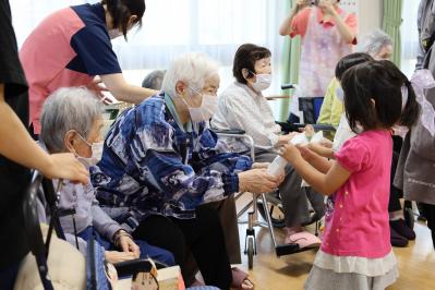 グループホームさくらの方から子供たちへプレゼントを渡す様子