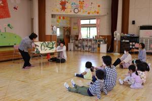 大きな絵本を読み聞かせる様子
